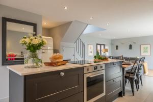 a kitchen with a counter with a vase of flowers at The Coach House Happisburgh in Happisburgh