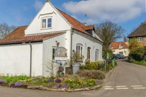 a white house with a red roof at The Coach House Happisburgh in Happisburgh
