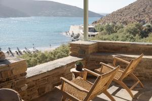 a patio with two chairs and a table and the ocean at Rabela's in Kollimpithra +26 photos
