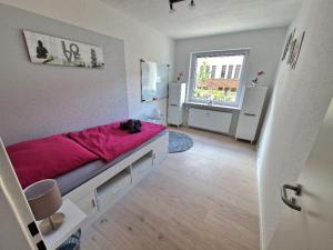 a bedroom with a bed with a pink blanket at Ferienwohnung Karlson in Wilhelmshaven
