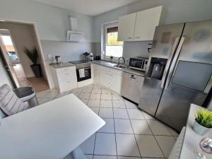 a kitchen with a refrigerator and a table in it at Ferienwohnung Karlson in Wilhelmshaven