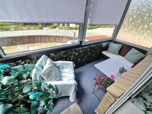 a living room with a couch and some plants at Ferienwohnung Karlson in Wilhelmshaven