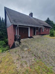 a small red house with a stone patio in front of it at CrisAnd 5 Anjofina in Altenau