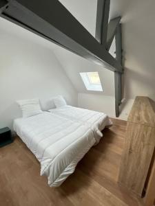 a white bed in a room with a window at La Maison Saint-Adrien in Boulogne-sur-Mer