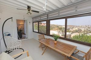 a living room with a wooden table and a swing at Aira Apartments in Azolimnos Syros