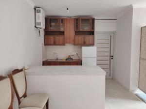 a kitchen with wooden cabinets and a white refrigerator at Gyumri in Gyumri +3 photos