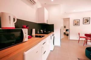 a kitchen with white cabinets and a counter top at Appart 5 Charmant 2 pièces avec parking in Aix-les-Bains