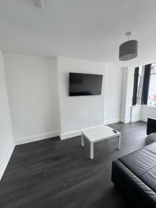 a white living room with a couch and a table at Theo apartment 150 meters from the winter gardens large groups welcome in Blackpool