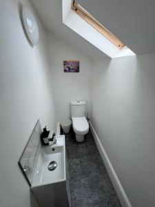 a white bathroom with a toilet and a sink at Theo apartment 150 meters from the winter gardens large groups welcome in Blackpool