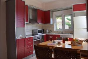 a kitchen with red cabinets and a wooden table at Agia Efimia Seaside in Agia Effimia in Agia Effimia