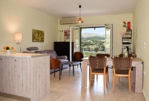 a kitchen and living room with a table and chairs at Myrtos Cottages Kefalonia in Divarata