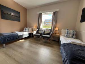 Una habitación con dos camas y una silla y una ventana. en Nordseter Apartments, en Lillehammer 75 fotos más