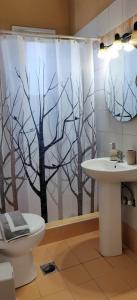 a bathroom with a shower curtain with a toilet and a sink at Myrtos Cottages Kefalonia in Divarata +184 photos