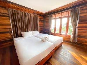 a white bed in a room with a window at Dusit Buncha Koh Tao by Riya Group in Ko Tao