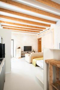 サッサリにあるHome Tola Raffinato appartamento in centroの白い壁と木製の天井のリビングルーム