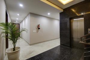 a potted plant in a hallway with a elevator at Limewood Stay Silver Studio Near Golf Course Road in Gurgaon