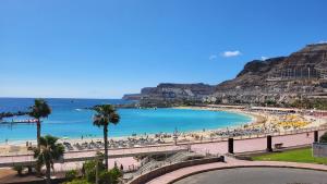 a beach with a bunch of people and the ocean at Beyond Amadores 11 in Mogán