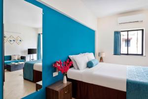 a bedroom with a large bed and a blue wall at Royale Assagao Resort - Near Vagator Beach in Assagao