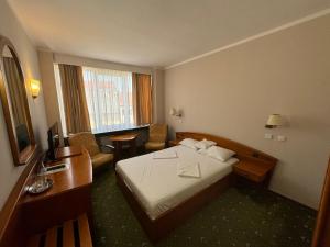 pokój hotelowy z łóżkiem i biurkiem w obiekcie Hotel Aurora w mieście Satu Mare +62 zdjęcia