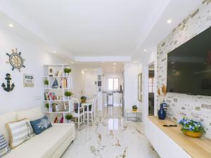 Una sala de estar con un sofá blanco y un televisor grande. en Cubo's El Faro Beach Apartment with Pool, en Mijas Costa