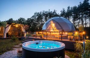 SitnoSëtnowa Glamping的院子里有一个带热水浴缸的大型圆顶帐篷
