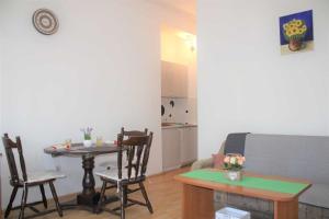 a living room with a table and chairs and a kitchen at Apartments Pidi in Neum
