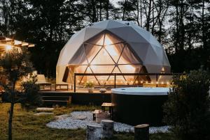 SitnoSëtnowa Glamping的圆顶房屋，院子里有热水浴缸