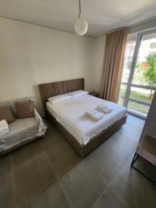a bedroom with a bed and a couch and a window at SanPietro Relax Apartment in Durrës +11 photos