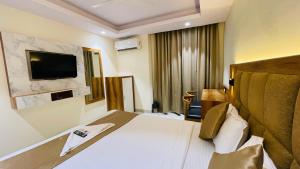 a hotel room with a bed and a flat screen tv at Hotel Arma Residency in Mumbai
