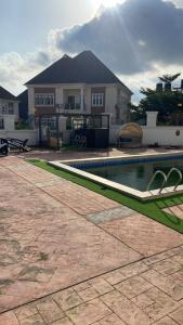 a house with a swimming pool in front of a house at Claramojisola -Eunice Apartment in Abuja +17 photos