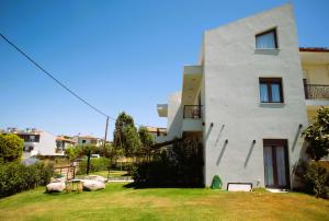 a white building with a yard in front of it at ACTA Luxury Rooms in Nikiti