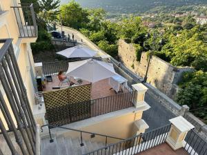 a balcony with tables and umbrellas on a building at Appartamenti Miravalle in Maratea
