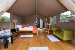 a tent with a bed and a chair and a table at Sleeping Warrior Camp Elementaita in Nakuru