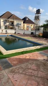 a swimming pool in front of a house at Claramojisola -Eunice Apartment in Abuja