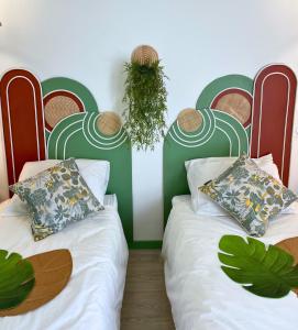two beds in a room with green and white at Boudoir - Clim-Wifi-Twin-Gare in Lourdes