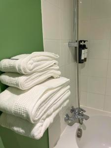 a stack of white towels sitting on a bathroom sink at Boudoir - Clim-Wifi-Twin-Gare in Lourdes +27 photos