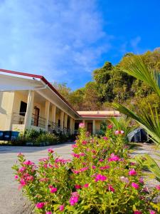 ein Gebäude mit rosa Blumen davor in der Unterkunft Stockton Inn Siquijor in San Juan