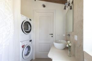 una lavanderia bianca con lavatrice e asciugatrice di Trullo Felicità a Putignano