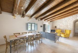un soggiorno con tavolo e sedie in legno di Trullo Felicità a Putignano