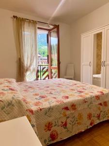 ein Schlafzimmer mit einem Bett mit geblümter Decke in der Unterkunft Castione della Presolana in Castione della Presolana