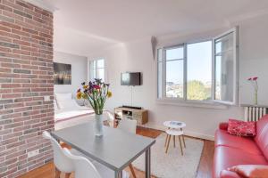 ein Wohnzimmer mit einem roten Sofa und einer Ziegelwand in der Unterkunft Eiffel tower view and terrace in Paris