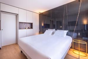 a bedroom with a large white bed and a wall at Kyriad Chateauroux Nord - Aéroport in Déols