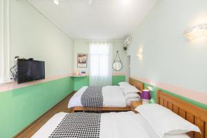 a room with three beds and a tv at Changsha Fuxiangyuan International Hostel in Changsha