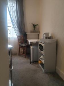 a small kitchen with a stove and a chair at Sweet Dreams in Luton