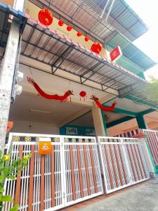a house with a white gate and a sign on it at The Betong Life Guesthouse in Betong