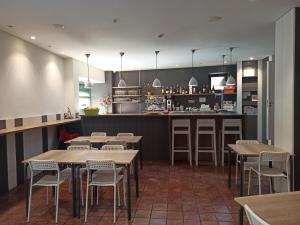 un ristorante con tavoli, sedie e un bancone di Hotel 3 Arcs a Besalú