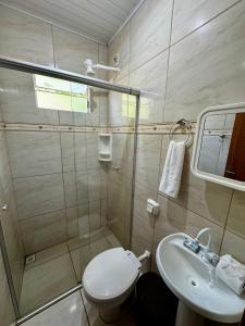 a bathroom with a shower and a toilet and a sink at Casa Flor do ipê Homes in Nobres +22 photos