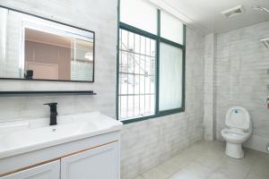 a white bathroom with a sink and a toilet at Changsha Fuxiangyuan International Hostel in Changsha +37 photos