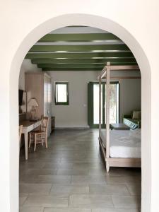 a bedroom with a bed and a desk and a table at Alona Luxury Villas in Arkasa