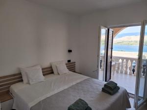 a bedroom with a bed with a view of the ocean at Sun Anna Apartments in Pag